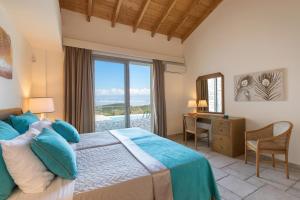 a bedroom with a bed and a desk and a window at Three Stones Villas by Rodostamo Collection in Kassiopi +59 photos