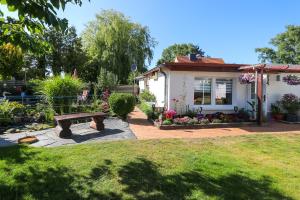 a house with a bench in front of a yard at Bungalow Wolfgang in Kühlungsborn