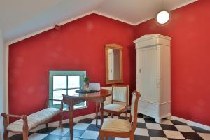 a dining room with red walls and a table and chairs at Herrenhaus Blengow App.15 in Blengow