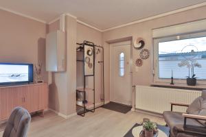 a living room with a television and a window at Bungalow Paul in Nienhagen