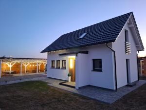 a white house with a black roof at Dom "Między jeziorami" na Kaszubach, 10 osób, jacuzzi, ognisko, kominek in Grabówko