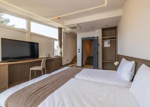 a hotel room with a large bed and a flat screen tv at Four Side Hotel in Prishtinë