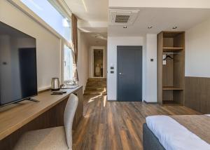 a bedroom with a large tv and a bed at Four Side Hotel in Prishtinë