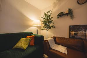 a living room with a green couch and a tree at Cozy 2 6 Guest Stay near Gangnam 6 min from Nakseongdae Station in Samgong