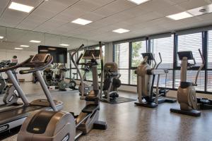 a gym with several treadmills and elliptical machines at Hôtel Restaurant Athena Spa in Strasbourg