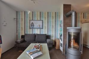 a living room with a couch and a fireplace at Sommersprosse in Börgerende-Rethwisch