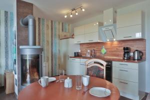 a kitchen with a table and a fireplace in it at Sommersprosse in Börgerende-Rethwisch