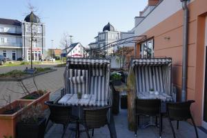 two chairs and a table on a patio at Sommersprosse in Börgerende-Rethwisch