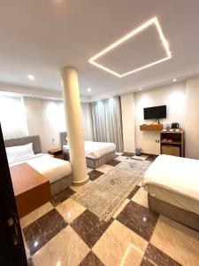 a hotel room with two beds and a television at Imperial Pyramids View Inn in Cairo