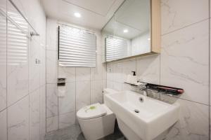 a white bathroom with a sink and a toilet at Cozy 2 6 Guest Stay near Gangnam 6 min from Nakseongdae Station in Samgong