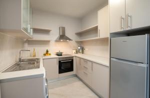 a white kitchen with a sink and a refrigerator at Kamara View Apt 2 in Agios Nikolaos