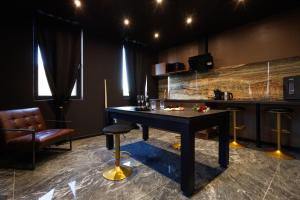 a bar with a table and chairs in a room at Suite Dark Luxe avec Écran géant de cinéma et jacuzzi in Clary