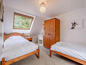 a bedroom with two beds and a wooden cabinet at 2 Bed in Llandovery oc-bn094 in Llandovery