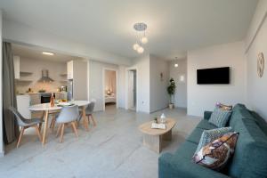 a living room with a blue couch and a table at Kamara View Apt 2 in Agios Nikolaos