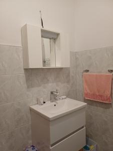 a bathroom with a white sink and a mirror at Apartman Čerkez in Stolac +11 photos