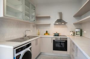 a white kitchen with a sink and a dishwasher at Kamara View Apt 2 in Agios Nikolaos