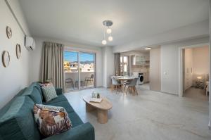 a living room with a blue couch and a table at Kamara View Apt 2 in Agios Nikolaos