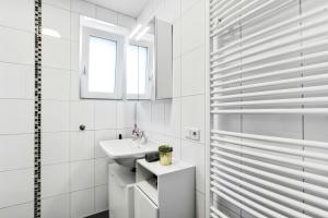 a white bathroom with a sink and a window at Ferienwohnung Südschwarzwald in Wehr +13 photos