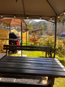 a park bench with an umbrella and a grill at Garden Apart in Predeal +87 photos