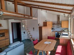 a kitchen and dining room with a table and red chairs at Adler Gaststube Hotel Biergarten in Bad Rappenau