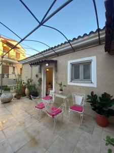 a patio with pink chairs and a table and a building at Maria,s house in Petra