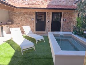 a patio with two chairs and a swimming pool at Retiro do Lavrador in Alvaiázere