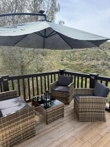 a patio with chairs and an umbrella on a deck at Sweet Home in Pego