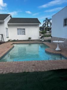 a swimming pool in front of a house at Let Us accommodation in East London