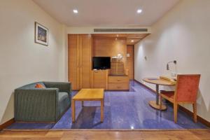 a living room with a couch and a table at Hotel Studio Estique in Pune +27 photos