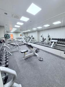 a gym with a lot of treadms and machines at AQMYRZA Inn in Zharkent