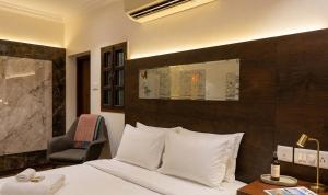 a hotel room with a bed and a chair at Amma Stays and Trails in Kotikulam