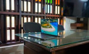 a laptop computer sitting on top of a glass desk at Amma Stays and Trails in Kotikulam