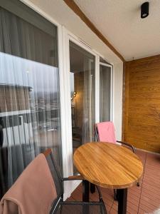 a wooden table and two chairs on a balcony at Apartament SANOVA 50 in Sanok