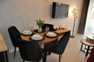 a dining room table and chairs with wine glasses and a table at Apartament SANOVA 50 in Sanok