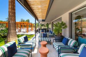 a row of chairs on a patio with palm trees at Cabú Hotel Adults Only - Small Luxury Hotels of the World in Faliraki