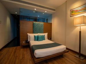 a bedroom with a large bed with blue pillows at Hotel Studio Estique in Pune