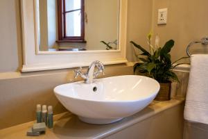 a bathroom with a white sink and a mirror at Gowrie Farm Golf Lodge in Nottingham Road +53 photos