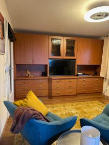a living room with a blue couch and a television at Ruhige Gartenwohnung in Königs Wusterhausen +10 photos