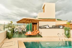 a house with a swimming pool and an umbrella at Riad May Fes Original & Spa in Fez