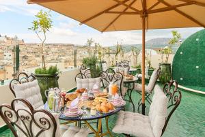 a table with a plate of food on a balcony at Riad May Fes Original & Spa in Fez
