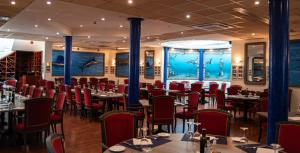 a restaurant with tables and chairs and an aquarium at Hotel Palacio del Mar in Santander