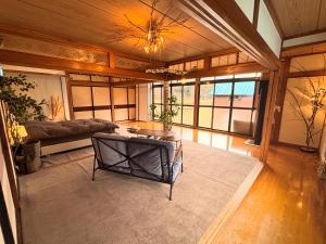 a living room with a couch and a table at 静かな森の古民家ステイ Tunagiつなぎ in Nishiwaga