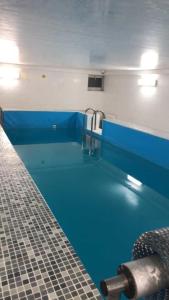a swimming pool with a blue floor in a bathroom at Міні Готель Особняк in Lviv