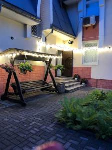 a patio with a gazebo and benches in front of a building at Міні Готель Особняк in Lviv