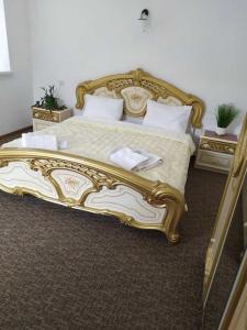 a gold and white bed in a hotel room at Міні Готель Особняк in Lviv +36 photos