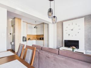 ein Wohnzimmer mit einer Couch und einer Uhr an der Wand in der Unterkunft Centrum Marzeń in Suwałki