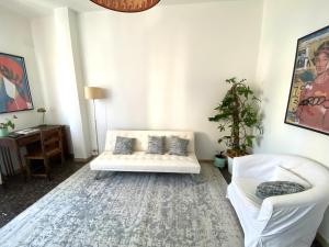 a living room with a white couch and two chairs at Casa Carmen Vicchio, natura vicino a stazione e Mugello Circuit in Vicchio +11 photos