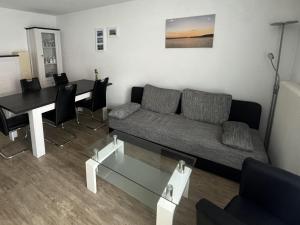 a living room with a couch and a table at Ferienwohnungen Wagner am Brombachsee in Pleinfeld