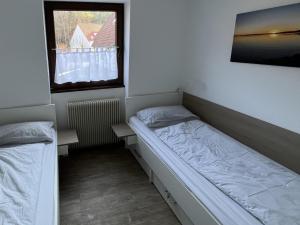 a small room with a bed and a window at Ferienwohnungen Wagner am Brombachsee in Pleinfeld