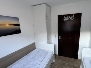 a small room with a bed and a black door at Ferienwohnungen Wagner am Brombachsee in Pleinfeld